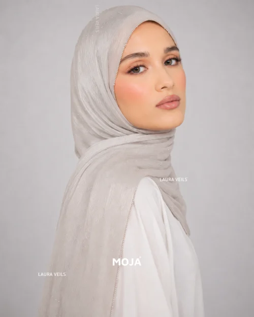 Woman wearing nude Moja organza shimmer hijab, silver chain lace border, draped instant style